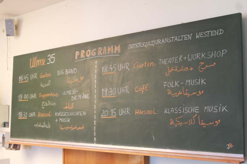 Programm des Festes auf deutsch und arabisch auf der Tafel im Hörsaal
